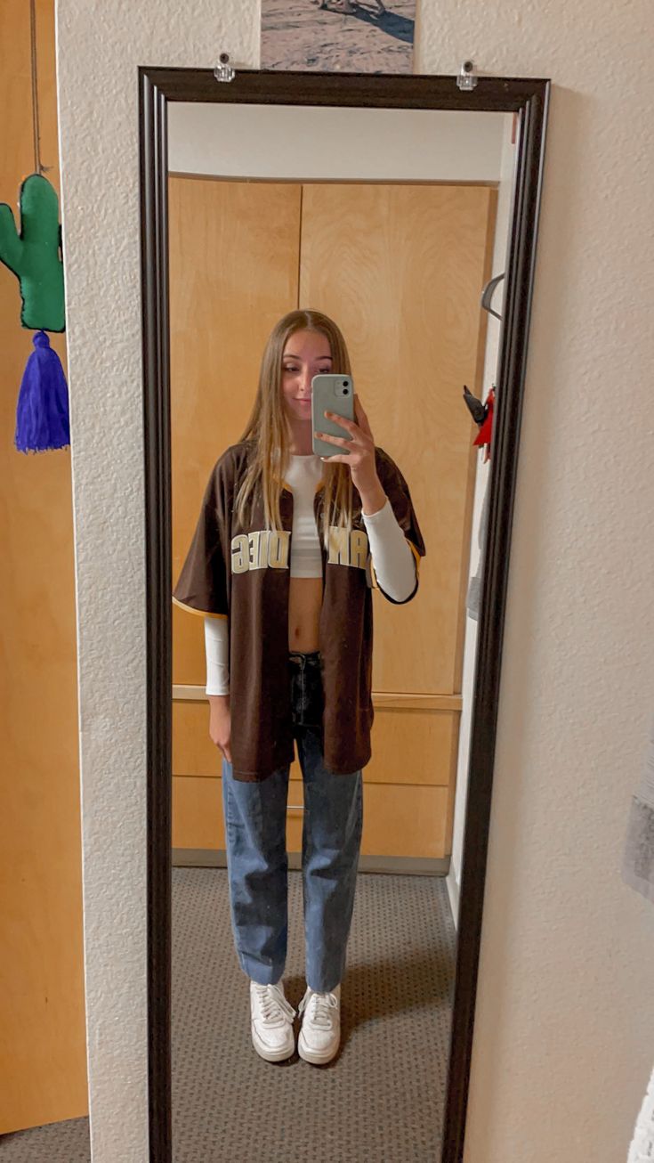 a woman taking a selfie in front of a mirror