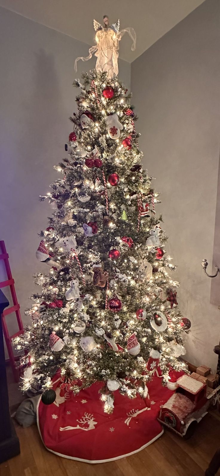 a white christmas tree with red and silver ornaments