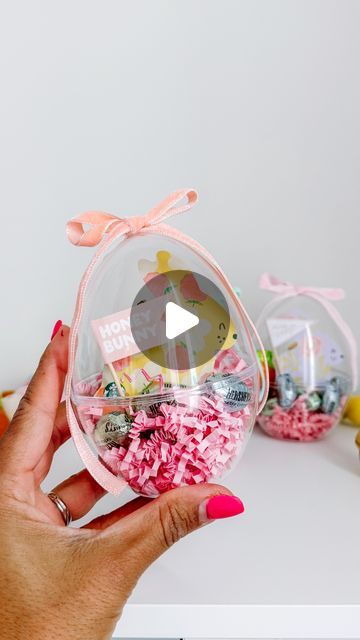 a person holding up a clear container filled with candies and other candy in it