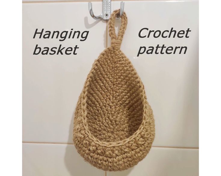 a crochet basket hanging on the wall next to a hook with two hooks