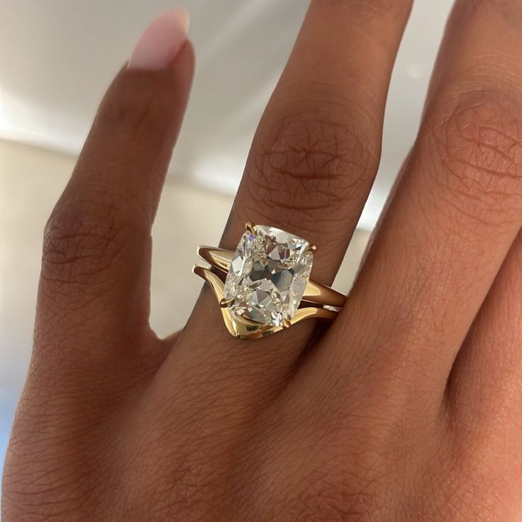 a woman's hand with a ring on it and a diamond in the middle