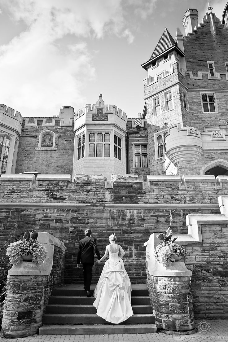 a bride and groom walking up the stairs to their wedding ceremony at an old castle