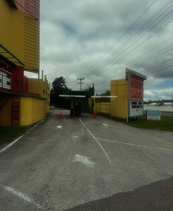 an empty parking lot in front of a yellow building