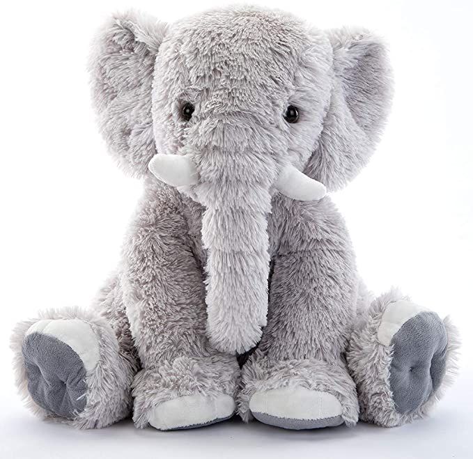 an elephant stuffed animal sitting up against a white background