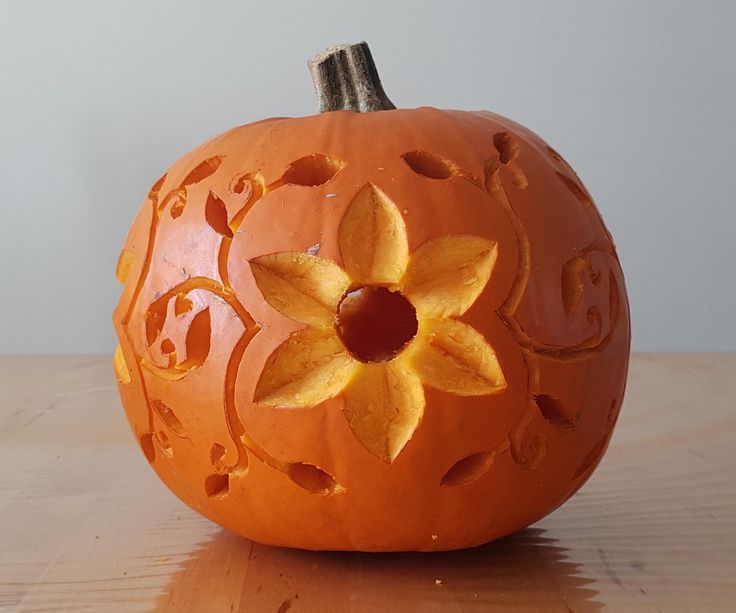 a carved pumpkin sitting on top of a wooden table