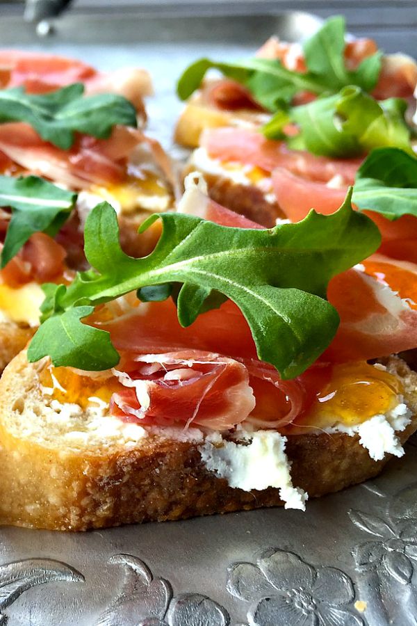 a close up of a pizza with toppings on the top and green leafy garnish