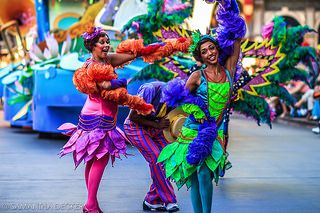 two women in colorful costumes dancing on the street