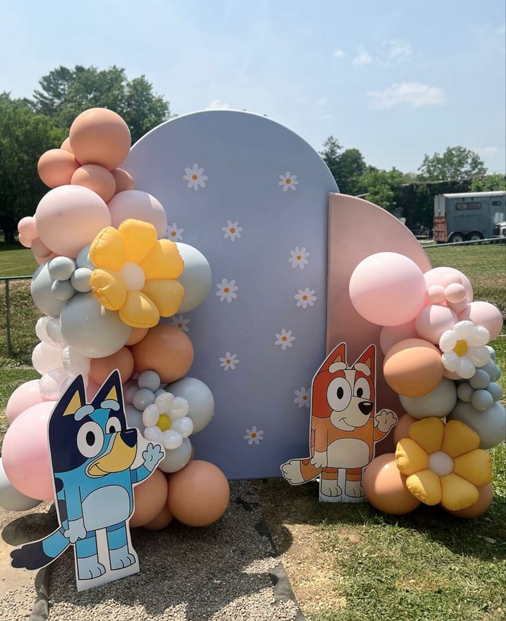 balloons are arranged in the shape of animals and flowers on display at an outdoor event