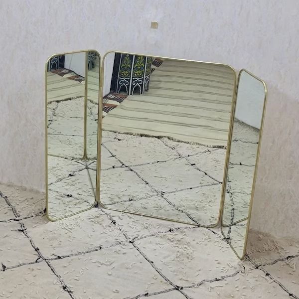 two mirrors sitting on top of a tiled floor