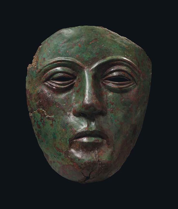 an ancient bronze head is shown against a black background