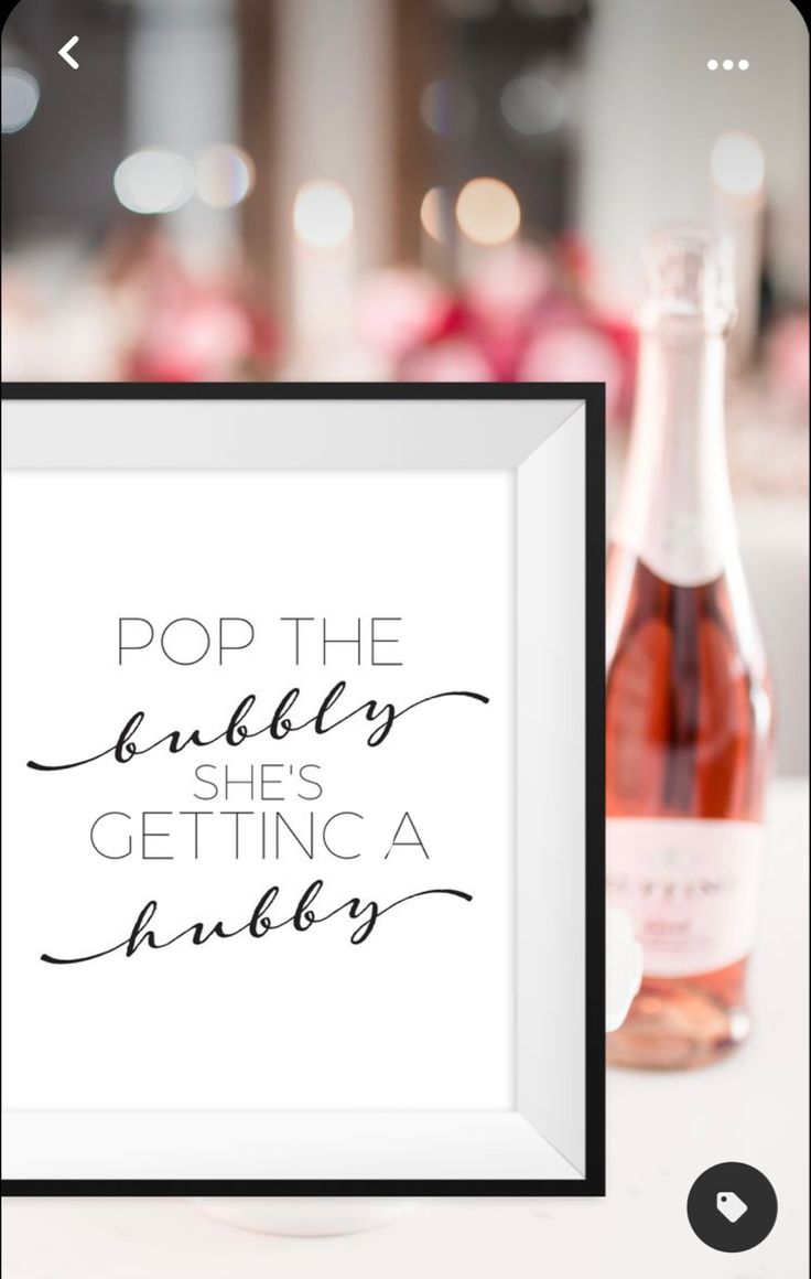 a bottle of wine sitting next to a framed sign that says pop the bubbles she's getting a juice