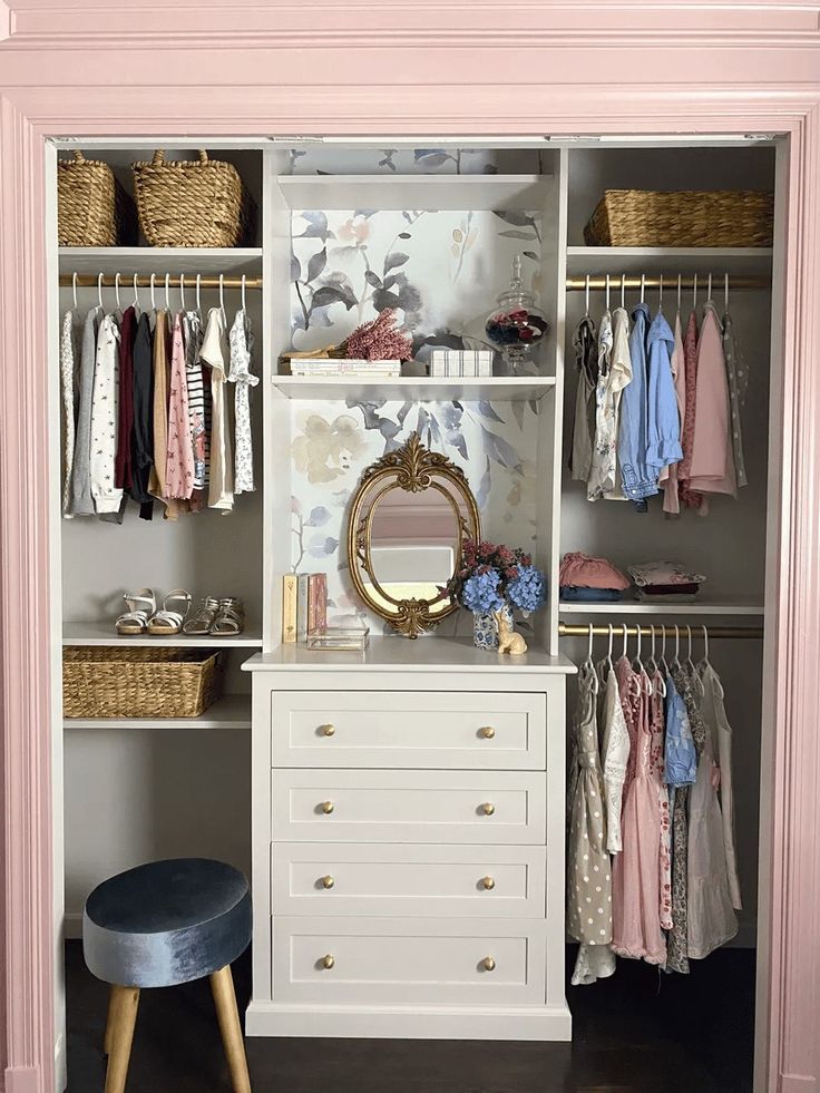 an organized closet with clothes, shoes and other items on shelves next to a stool