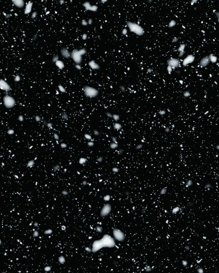 snow flakes are falling down on the black background with space for text or image