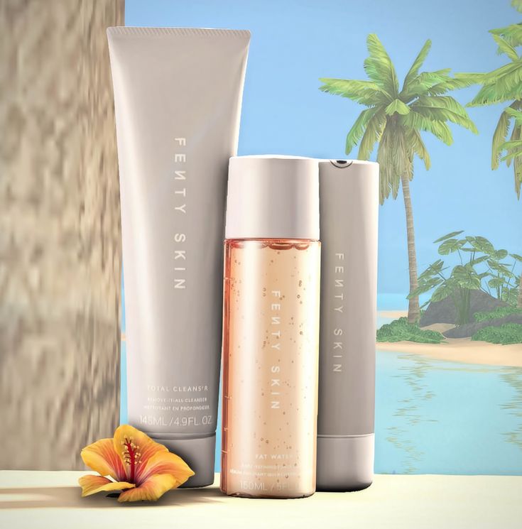 three different types of skin care products sitting on a table next to a beach and palm tree