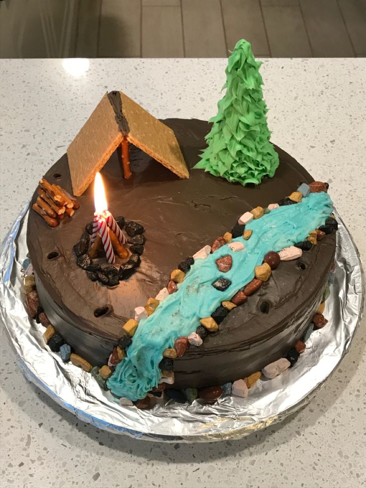 a birthday cake with a lit candle in the middle on top of a countertop