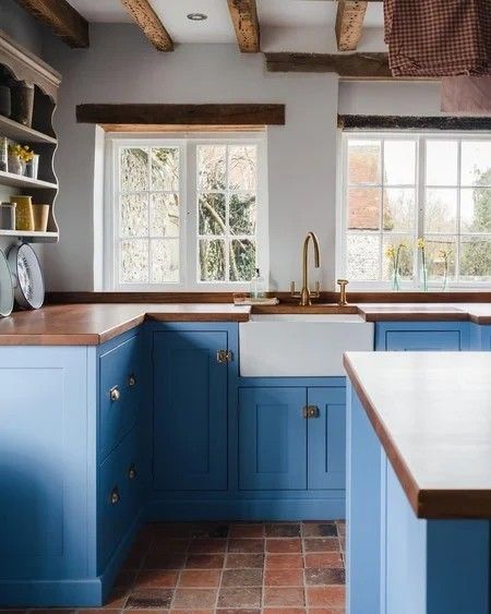 a kitchen with blue cabinets and wooden beams on the ceiling is pictured in this image