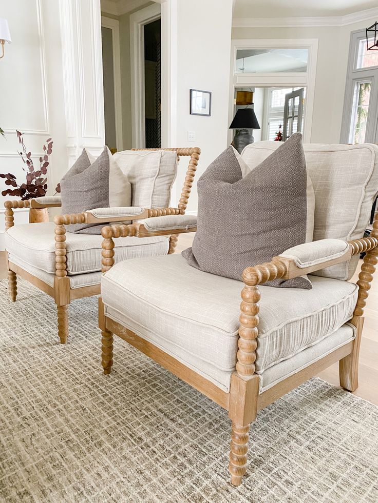 two wooden chairs sitting on top of a rug