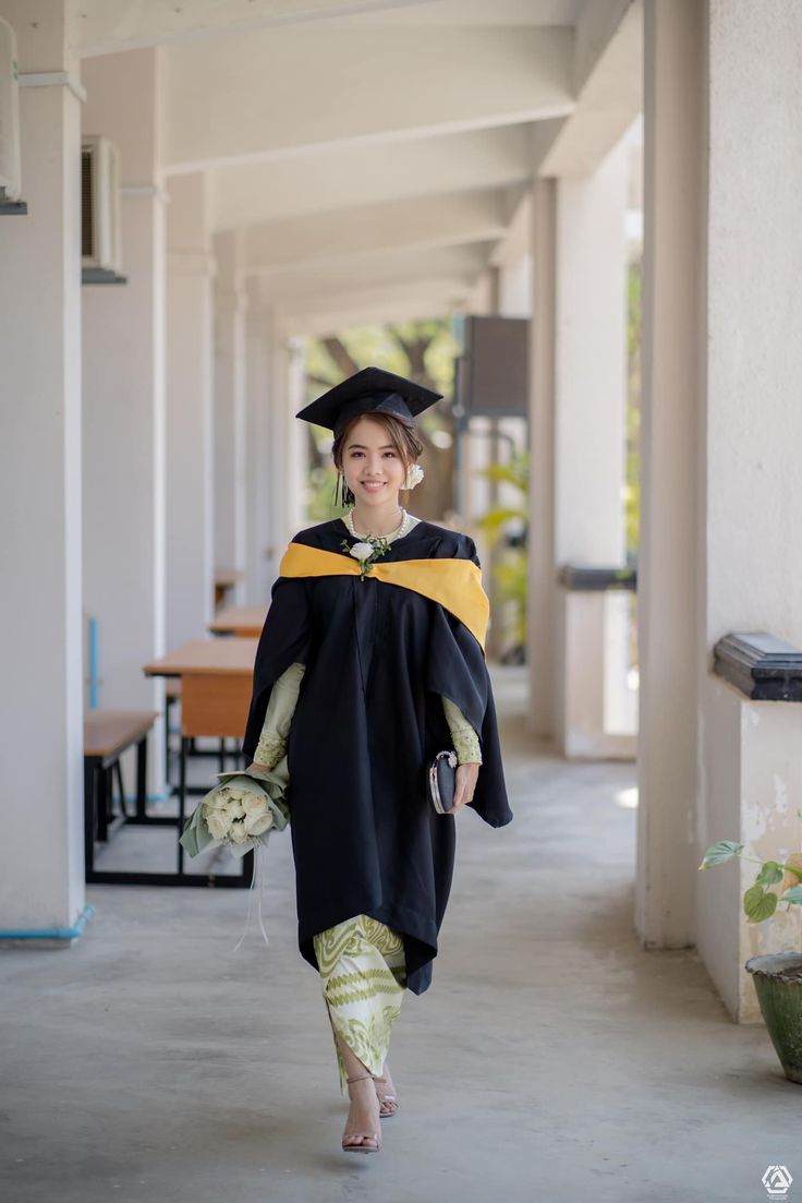 a woman in a graduation gown walks down the hallway with her hand on her hip