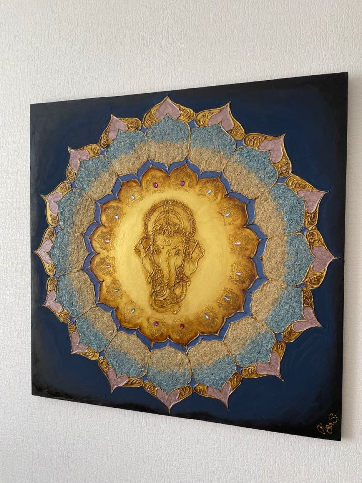 a painting on the wall with an elephant head in it's center surrounded by gold and blue circles