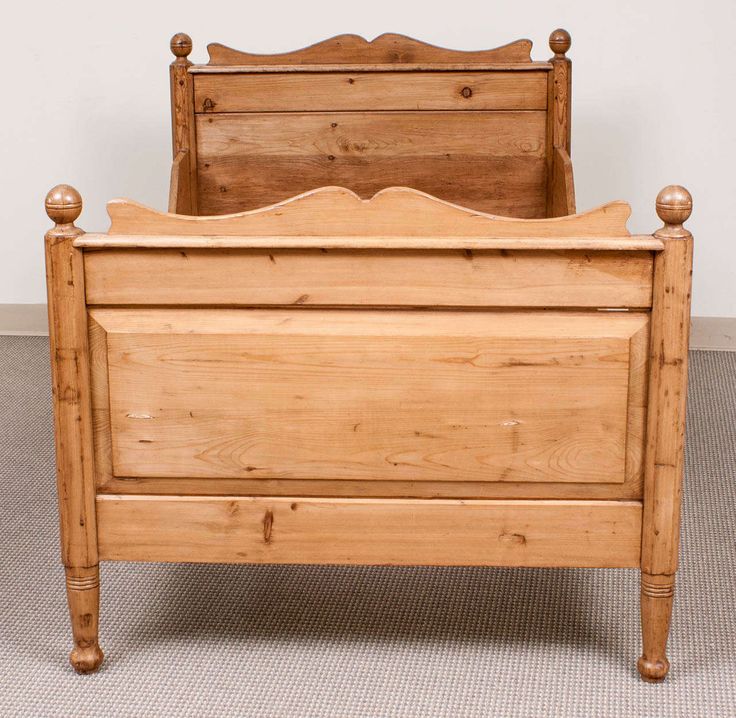 an old wooden bed frame with no headboard and foot board on carpeted floor