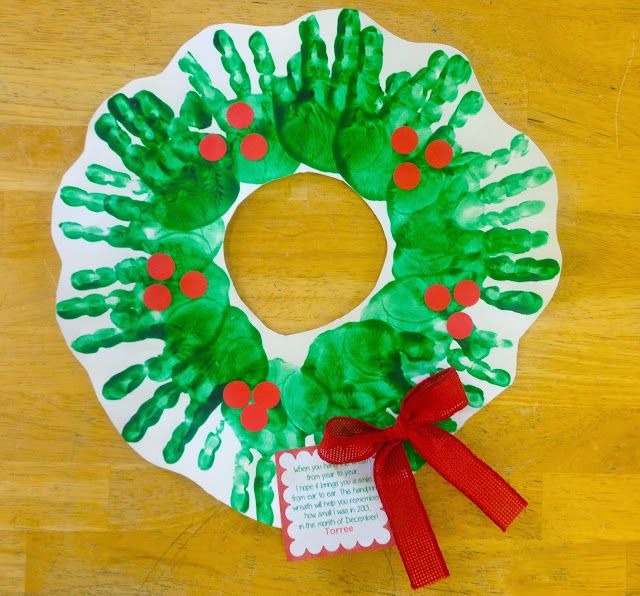 a paper plate wreath with handprints on it