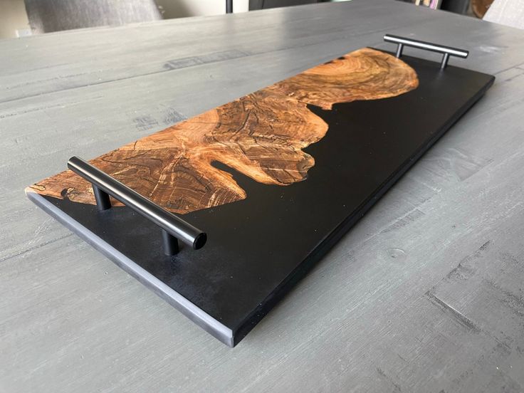 a wooden table with a black metal stand on it's side and an image of a tree in the middle