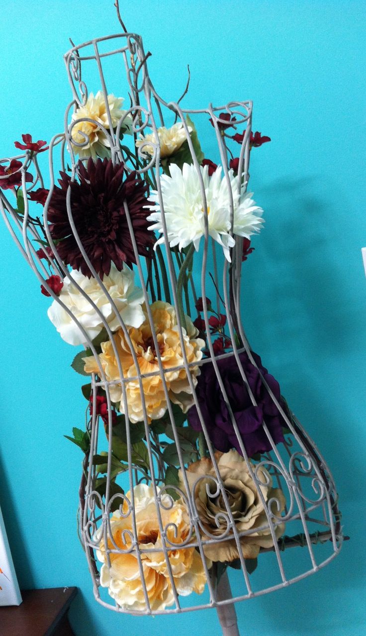 there is a metal rack with flowers in it