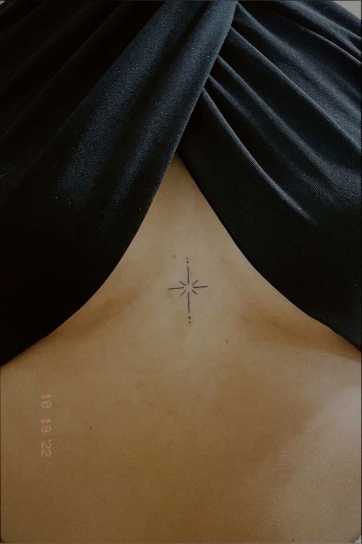 a cross tattoo on the back of a woman