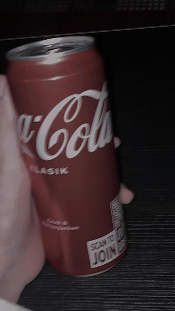 a coca cola can being held by someone's hand