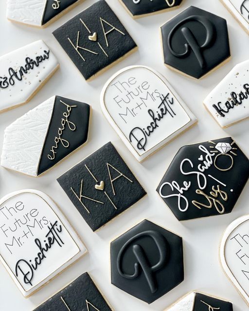 decorated cookies with black and white icing are arranged on a table together in the shape of hexagons