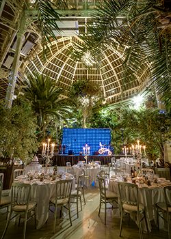 the inside of a building with tables and chairs set up for a formal dinner or function