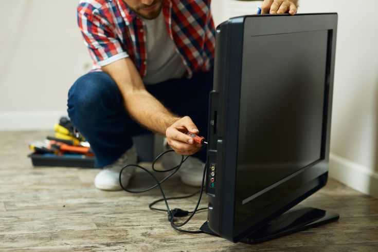 a man is working on a computer monitor