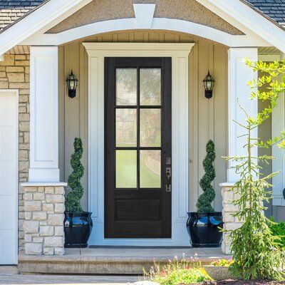 a front door with two planters on either side