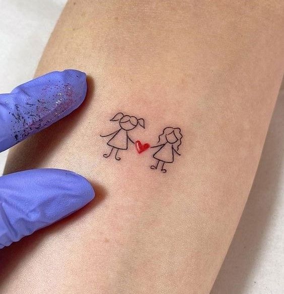 a person holding their arm with a small tattoo on it