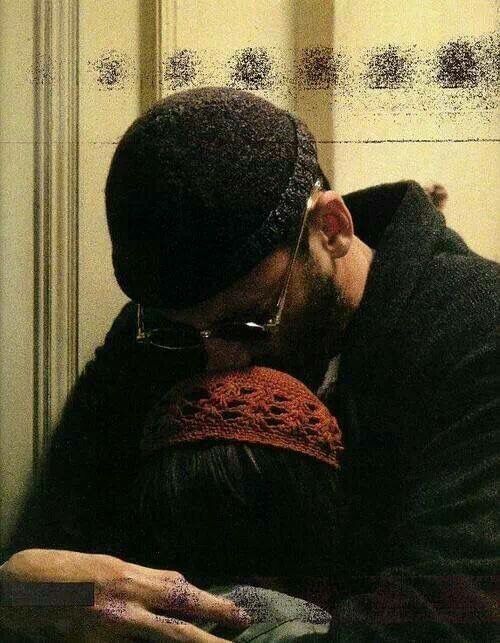 a man and woman kissing each other in front of a mirror