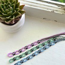 four bracelets sitting on top of a window sill next to a potted plant