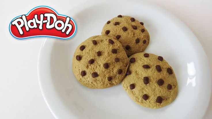 three chocolate chip cookies on a plate with the word play - doh in front of them