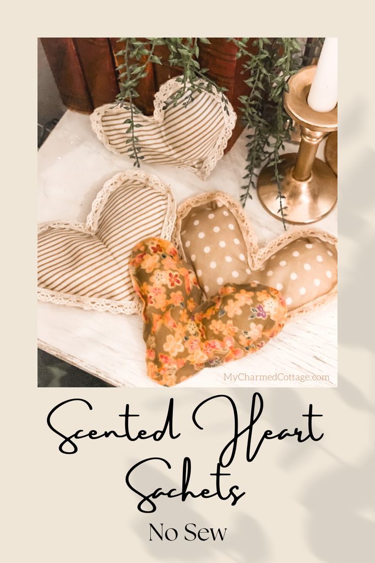 two heart shaped cushions sitting on top of a table next to a candle and potted plant