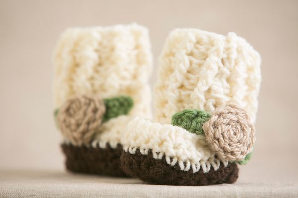 there is a pair of crocheted boots with flowers on them