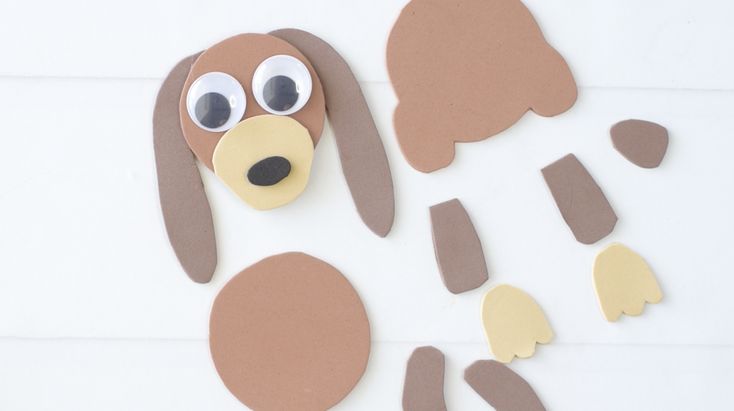 a paper cut out of a dog's face and ears on a white surface