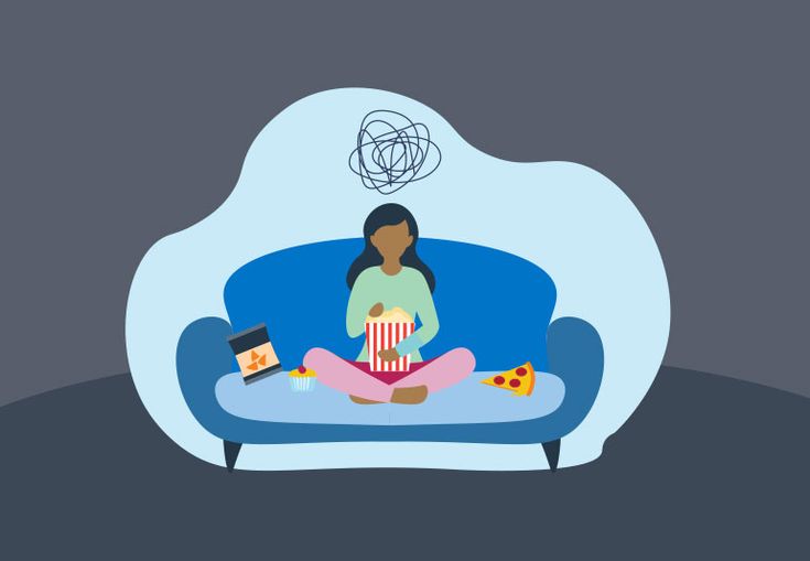 a woman sitting on a couch with a remote control in front of her and watching tv