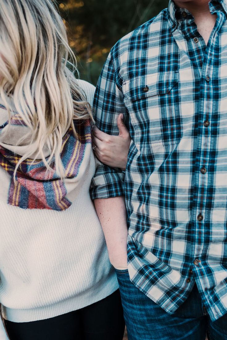 a man and woman standing next to each other with their arms around each other's shoulders