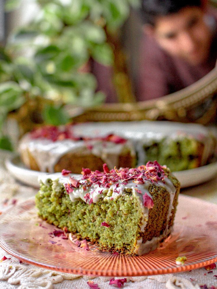 a piece of cake sitting on top of a pink plate next to a green cake