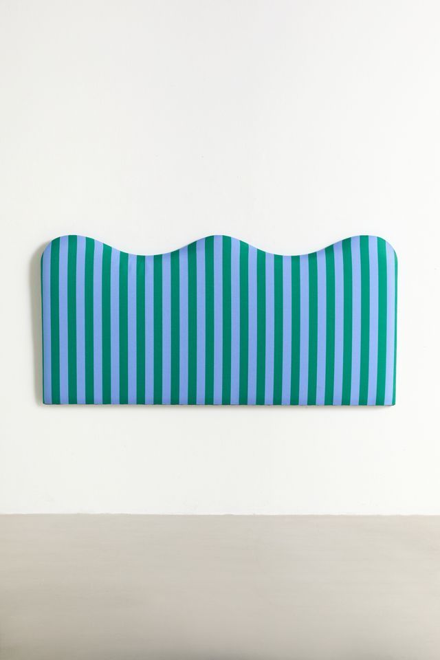 a blue and white striped headboard sitting on top of a table