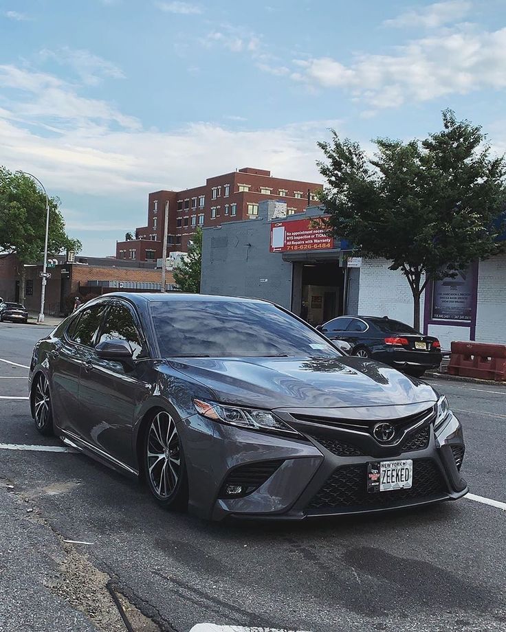 a gray car is parked on the side of the road