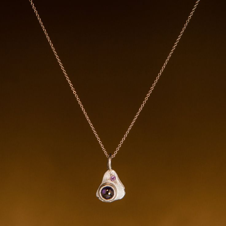 Description This sweetly asymmetrical sterling silver pendant is set with a bright purple iolite cabochon in 14k yellow gold, accented with a sparkling amethyst star-set into a backdrop of textured silver. With its calming purple hues and organic backplate, this beautiful necklace is sure to become a talisman you will cherish for years to come. This necklace was made using sterling and fine silver reclaimed from our studio. The cabochon-cut iolite weighs 0.5 carats and measures approximately 6mm Purple Amethyst Jewelry With Pearl Pendant, Amethyst Pendant With Polished Finish, Amulet Necklace, Bespoke Jewellery, Bright Purple, Jewelry Repair, Purple Hues, Beautiful Necklace, Fine Silver