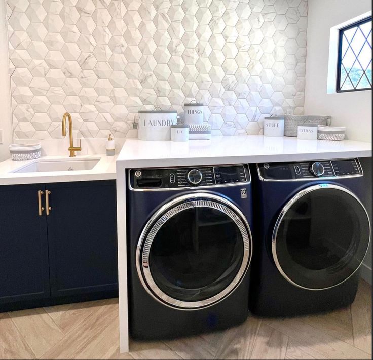 a washer and dryer in a kitchen with white tile backsplashing