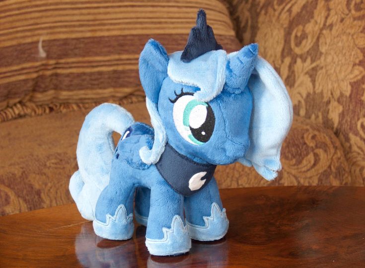 a small blue pony sitting on top of a wooden table