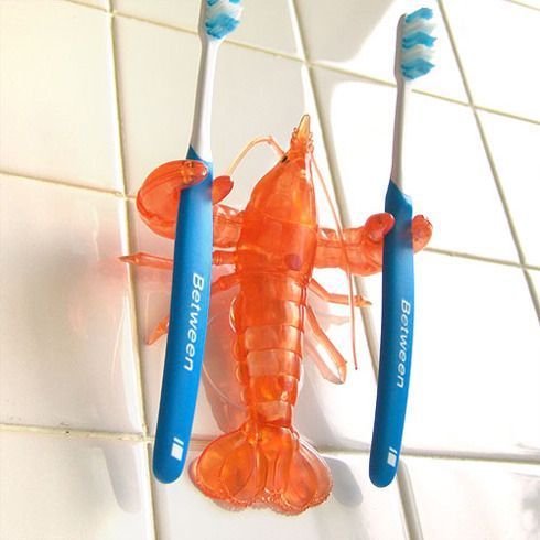 two blue and orange toothbrushes sitting next to each other on a tiled floor