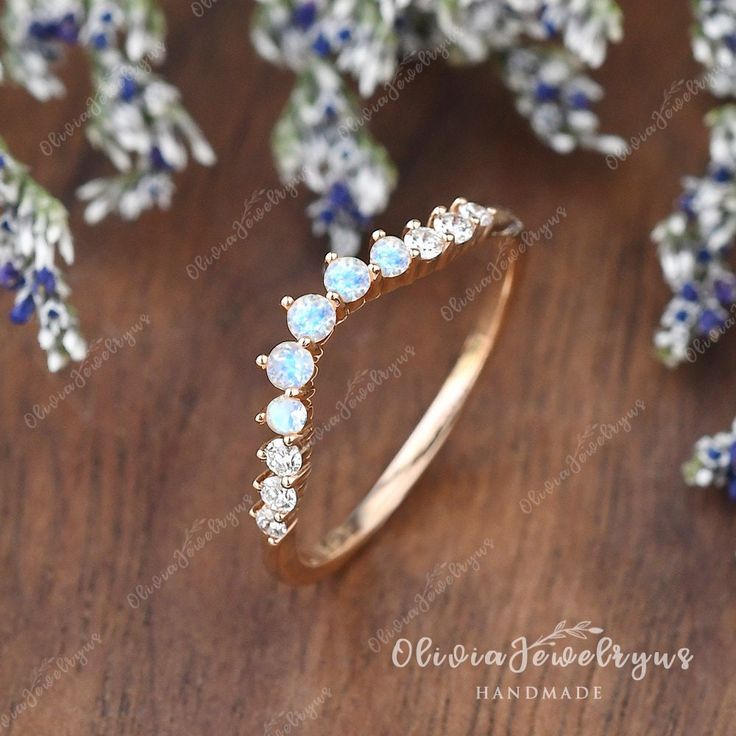 an opal and diamond ring on a wooden table